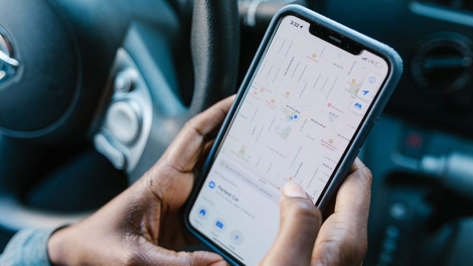 Hands holding a smartphone showing a GPS map, used for geofenced attendance for field employees