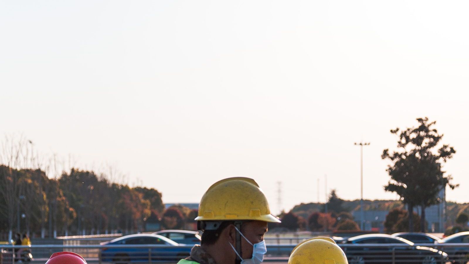 Workers in hard hats and reflective vests walking by the water during a field inspection