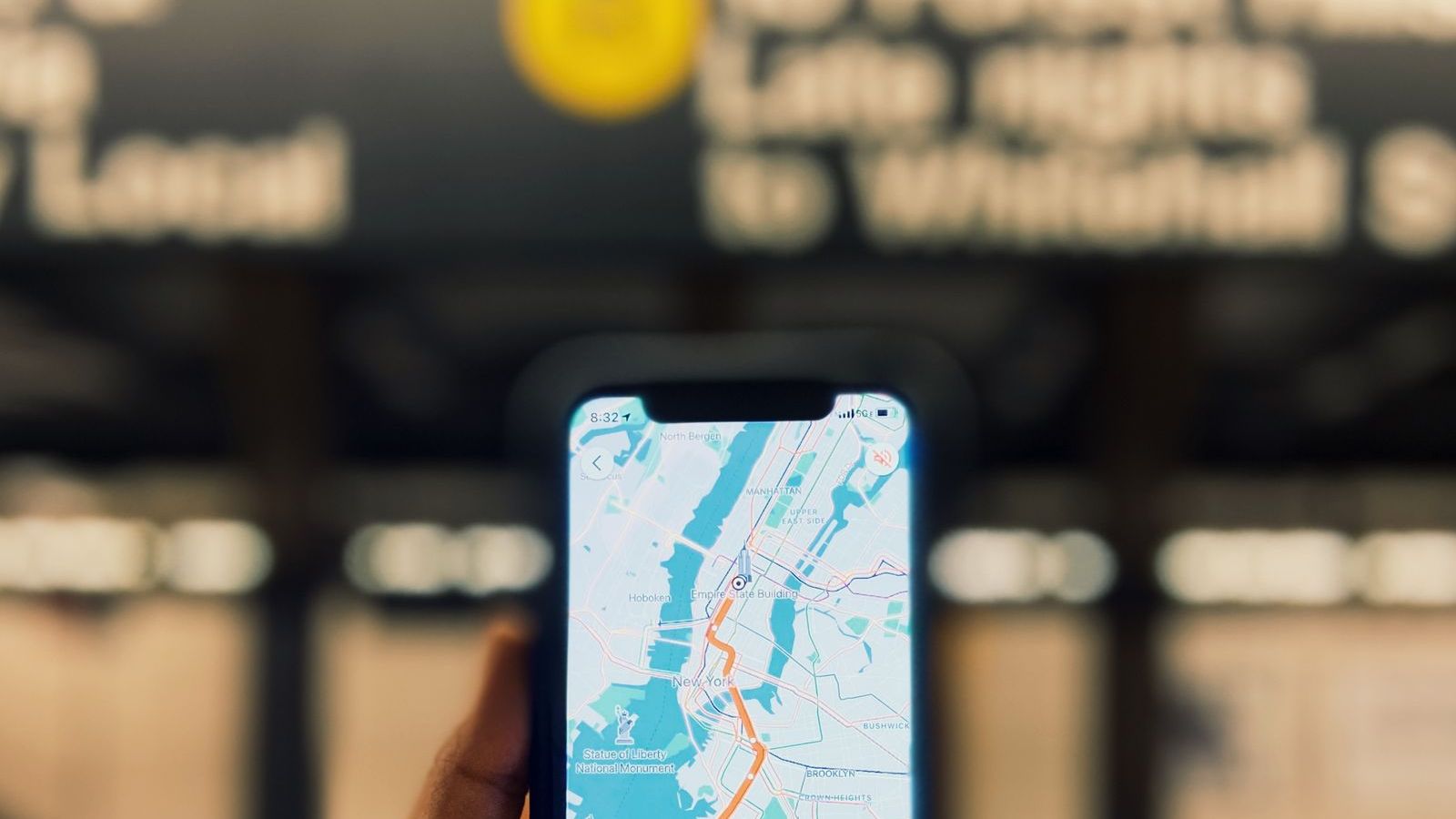 Person holding a phone showing a map route, representing route optimisation software for field teams